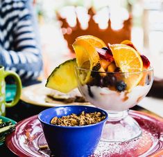 a bowl filled with fruit and granola on top of a plate