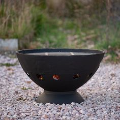 a black bowl sitting on top of gravel