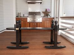 a kitchen with an oven, stove and two black stands in front of the counter