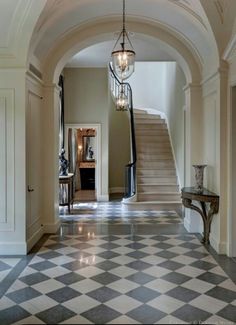 an entry way with a checkered floor and chandelier