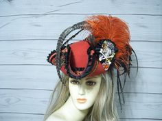 Ladies one of a kind burnt orange woolen pirate/tricorn hat with black and orange trimmings, black cocarde with a large 4" crowned and jeweled skull, The other side has a metal octopus. A combination of burnt orange ostrich feathers and all natural coque feathers. Beautiful hat. Great for many events.  This hat has a 4"-fold up brim, this is NOT an oversized pirate hat so please keep that in mind. Please measure your head! This is important as I do not take returns and all sales are final.  This hat is 22.5" for the inside circumference with a built-in hat sizer tie. I cannot make the circumference bigger so please keep that in mind. Check out my shop for more Pirate and other style hats. I ship Priority mail. I ship many times a week. If you need your item quicker let me know your zip cod Pirate Style Costume Hat For Halloween, Pirate Style Brimmed Costume Hat For Parties, Pirate Costume Accessories For Halloween, Pirate Costume Hat For Halloween, Pirate Style Halloween Costume Accessories, Pirate Costume Hats And Headpieces For Halloween, Handmade Red Costume Hats And Headpieces, Adjustable Wide Brim Pirate Hat, Pirate Head Accessories