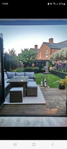 an outdoor living room with patio furniture and landscaping