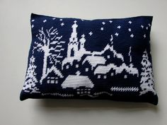 a blue and white knitted pillow with an image of a castle in the night sky