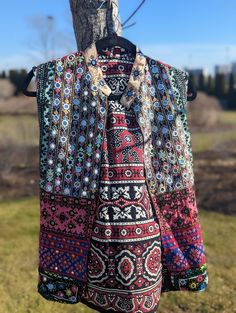 This Patchwork jacket is made of Hand embroidered panels stitched together to form a boho style vest. These embroidered patches were sourced from Tharparkar region of Sindh and some parts of Balochistan. Each section of embroidery consists of different styles of threadwork and mirror work native to the region, with some overlapping techniques of Baloch styles. Some of the styles of embroidery included are but not limited to: kaacha taanka, mirror work, Balochi tanka. The fabric itself has been e Bohemian Multicolor Patchwork Vest, Multicolor Hippie Festival Vest, Bohemian Patchwork Vest For Festivals, Bohemian Patchwork Vest For Fall, Bohemian Multicolor Embroidered Vest For Festivals, Bohemian Embroidered Vest For Festivals, Fall Bohemian Vest With Patchwork, Fall Bohemian Patchwork Vest, Bohemian Boho Print Festival Outerwear