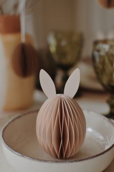 a white plate topped with an ornament shaped like a bunny's head