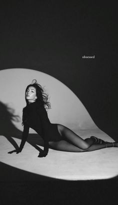 a woman laying on top of a white table next to a black and white photo