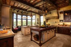 a large kitchen with an island in the middle and lots of windows on both sides