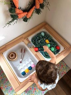 a young child playing with an easter egg tray