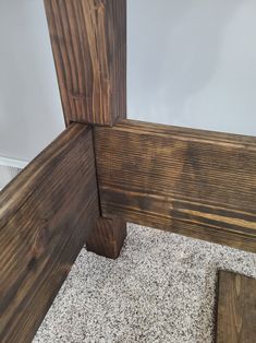 the corner of a wood paneled room with carpeting and white walls behind it