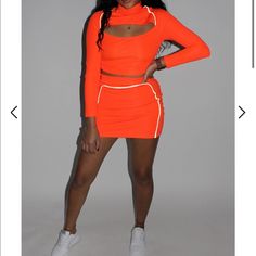 Cute Neon Orange Skirt Set With Reflective Details 2 Piece Set With Long Sleeve Top With Slipt In Middle Stretch Two-piece Mini Skirt, Casual Fitted Two-piece Skirt Set, Sporty Mini Skirt For Spring Day Out, Casual Stretch Orange Mini Skirt, Casual Two-piece Mini Skirt, Fitted Orange Mini Skort, Orange Stretch Skort For Spring, Stretch Orange Skort For Spring, Spring Orange Stretch Skort