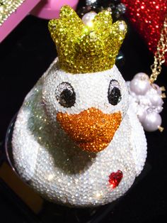 a white and gold snowman ornament with a crown on it's head