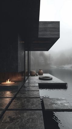 an outdoor fire pit next to a body of water