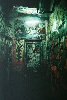 a dark room with graffiti all over the walls