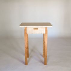 a small wooden table sitting on top of a white floor