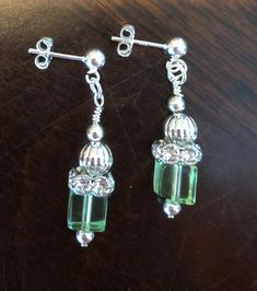 These beautiful crystal cube earrings will bring just the pop of color and sparkle you are looking for to enhance any holiday or formal outfit.  Made of 8mm crystal cube beads, round silver and clear crystal rondelles, silver sculpeted beads and silver tone findings, these earrings have a drop of 1.38 inches, that will frame your face beautifully!  Ask us about other color options. Cube Earrings, Blue Onyx, Cube Beads, Rosary Bracelet, Green Crystal, Etsy Earrings Dangle, Formal Outfit, Spring Green, Green Crystals