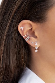 a woman wearing three different types of ear piercings