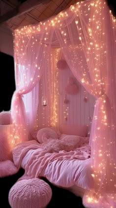 a pink bedroom with lights on the walls and bed canopy over it's headboard