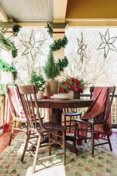 a table with chairs and potted plants on top of it in front of a window