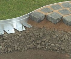 a pile of dirt sitting next to a metal rail on top of a grass covered field