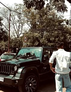 a man standing next to a black jeep