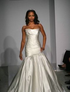 a woman in a wedding dress on the runway