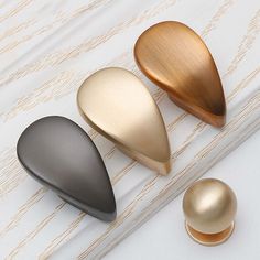 three different colored knobs sitting on top of a white surface