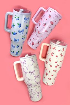 four different colored coffee mugs on a pink background with the same pattern and color