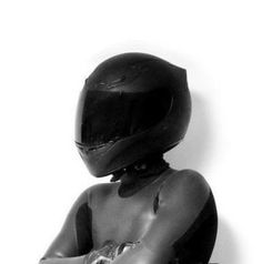 a black and white photo of a person wearing a motorcycle helmet with their arms crossed