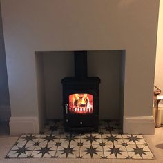 a fireplace with a tile floor and a fire place in the corner, it is lit up