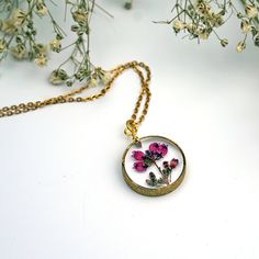 "Real pressed Heather Flowers are encased in jewelry grade resin within this stunning stardust raw brass circle bezel. The setting has a textured finish, which gives just a bit of extra dazzle. Attached to a matching 18\" chain and measures 3/4\" diameter. Hangs on a labelled card, easy for gifting!" Gold Brass Jewelry With Pressed Flowers, Nature-inspired Gold Jewelry With Pressed Flowers, Botanical Style Gold Resin Jewelry, Nickel Free Gold Botanical Jewelry, Gold Resin Jewelry With Flower Charm, Nickel-free Gold Botanical Jewelry, Delicate Gold Resin Jewelry, Nickel-free Botanical Gold Jewelry, Rose Gold Necklace With Pressed Flowers