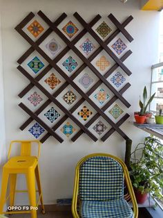 a chair and table in front of a wall with colorful tiles on it