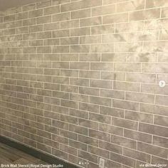 an empty room with white brick walls and wood floors