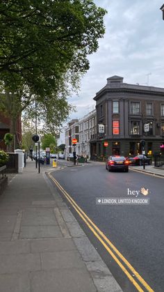 an empty city street with cars parked on the side