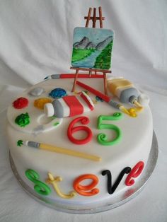 a birthday cake decorated with an easel and painting supplies