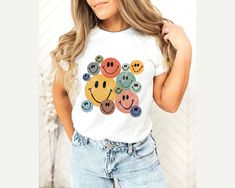 Retro Smiley Faces Shirt, Smile Face T-Shirt, Vintage Smiley Face Shirt, Trendy Shirts for Women Youth Kids Toddler Baby,Smiling Emoji Shirt Thank you so much for choosing us! How To Order 1️⃣ Please review all the information provided before placing an order. 2️⃣ Select the shirt type and size using the drop down menu. 3️⃣ Select the color of the shirt using the following drop down menu. 4️⃣ Once all your desired items are in your cart you may complete your order by entering your payment method Playful White T-shirt With Smiley Face, Fun Cotton T-shirt With Smiley Face, Playful White Top With Smiley Face, Fun White Tops With Cartoon Print, Fun White Top With Cartoon Print, White Fun Tops With Cartoon Print, White Top With Cartoon Print, Fun White Pre-shrunk Shirt, White Playful T-shirt With Smiley Face