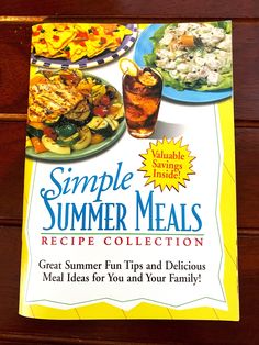 a cookbook on a wooden table with pictures of food and drinks in the background