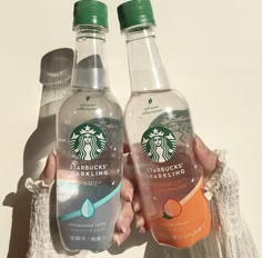 two bottles of starbucks sparkling water in their hands