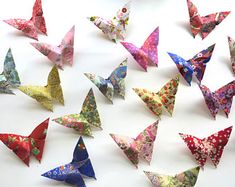 a group of origami butterflies sitting on top of a white table next to each other