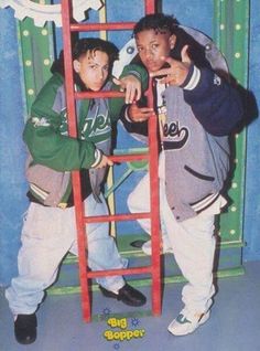 two young men standing next to each other in front of a ladder with the word boo cooper on it