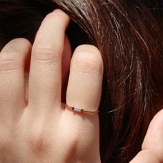 a close up of a person's hand with a gold ring on their finger