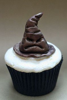 a cupcake topped with chocolate frosting and a witches hat