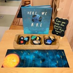 there are books and magnets on the table with solar system in front of them