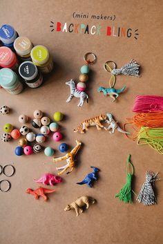 there are many small toys and beads on the table next to each other with words that read mini makers jackjack binge