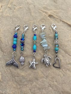 five different bracelets with charms on the beach