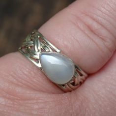 Handmade, Natural Sri Lankan Moonstone Sterling Silver Ring Size 7.5 Featured in this listing is a sterling silver, handmade, natural stone ring. This lovely ring features a beautiful, Natural Sri Lankan Moonstone in a teardrop shape, set east to west, and is 7x10mm. This beautiful Moonstone has beautiful white glow, the band is wide at 9mm, and features a rope design. This handcrafted ring is all set by hand, and into .925 Sterling Silver. Gemstone: Natural Sri Lankan Moonstone (7x10mm) Ring Si Adjustable Teardrop Moonstone Ring In Sterling Silver, Silver Teardrop Moonstone Ring For Anniversary, Hallmarked Moonstone Ring For Anniversary, Silver Teardrop Moonstone Ring, Handmade Silver Teardrop Moonstone Ring, Adjustable Silver Moonstone Ring Hallmarked, Adjustable Silver Hallmarked Moonstone Ring, Handmade Silver Opal Teardrop Ring, Handmade Silver Teardrop Opal Ring