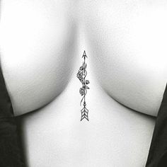 a woman's breast with an arrow tattoo on her left side and flowers in the middle