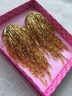 two pieces of gold foil in a pink box