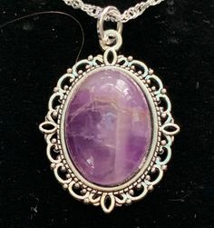 Very nice looking,.  Amethyst is one of the most famous and prominent crystals because of its beautiful coloration as well as its spiritual and literal meaning.  The spiritual meaning of Amethyst is groundedness, tranquility, and calm. The literal meaning of Amethyst is "not intoxicated".  To this ancient, wise culture, the Amethyst crystal was of the utmost importance, and the myth associated with it still lives on inside it to this day.  You can immediately feel peace of mind by simply looking at this brilliant crystal. In fact, its radiant purple and white colors have represented the sobriety of emotions and spirit throughout history.  It is also the traditional gift for a couple's 33rd wedding anniversary because 33 is the number of divine protection. Stone Size: 18x13 mm.   USPS First Purple Amethyst Oval Pendant Jewelry, Spiritual Purple Cabochon Jewelry, Purple Gemstone Oval Pendant Necklace, Purple Gemstone Necklace With Oval Pendant, Purple Oval Gemstone Necklace, Spiritual Purple Oval Jewelry, Spiritual Oval Purple Jewelry, Purple Oval Spiritual Jewelry, Purple Oval Stones Jewelry