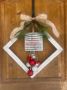 a wooden door decorated with christmas ornaments and ribbon hanging from it's front door