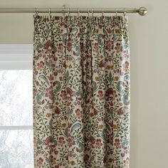 the curtain is hanging in front of a window with floral print on it and has a metal rod